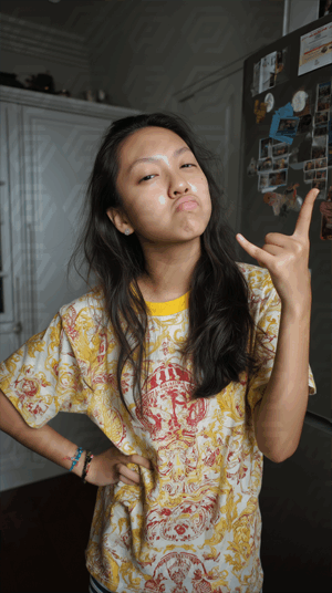 Playful Girl Making Rock Hand Sign Indoors
