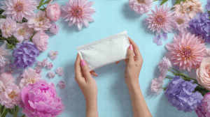 Hands Presenting Blank Sachet With Flowers Beauty Product Mockup