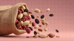 Healthy Nut Mix and Raisins Pouring From Sack on Pink Surface