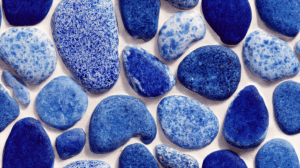 Assorted Deep Blue Pebbles on Light Background