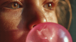 Extreme Close-Up of Child with Bubblegum Bubble and Shimmering Skin