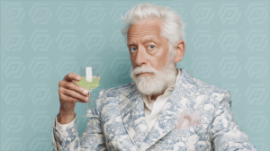 Mature Gentleman in Blue Floral Suit Holding a Glass of Green Drink