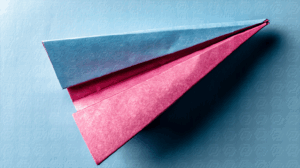 Blue And Pink Origami Plane On Textured Surface