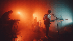 Indie Band Performing Live in Warm Red Stage Lighting