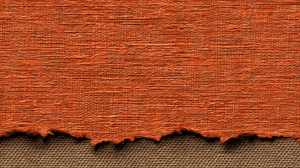 Torn Orange Canvas Fabric Layer Over Woven Background